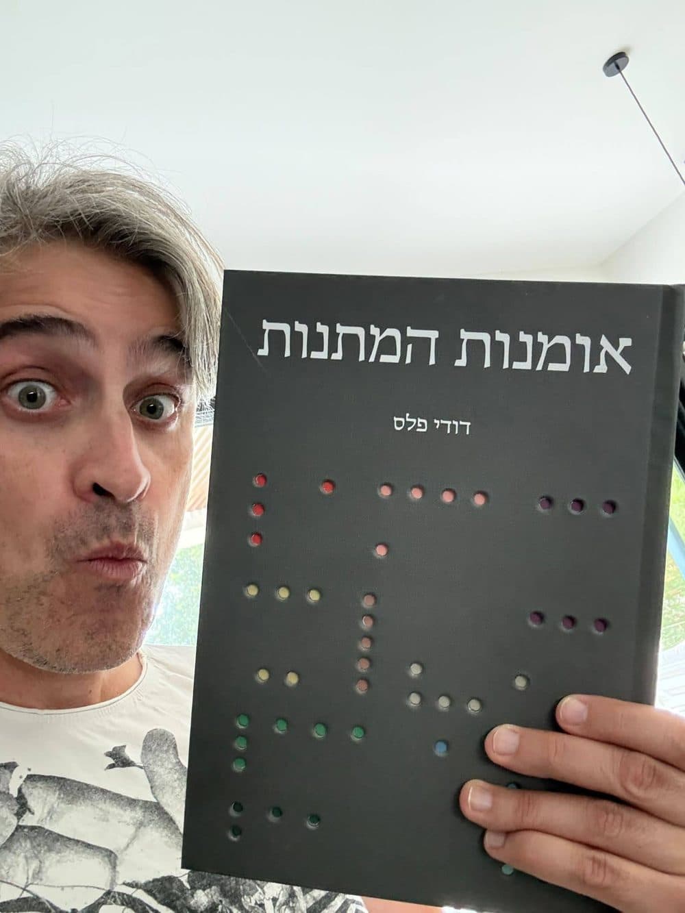 דודי פלס מחזיק את הספר ‘אומנות המתנות’
